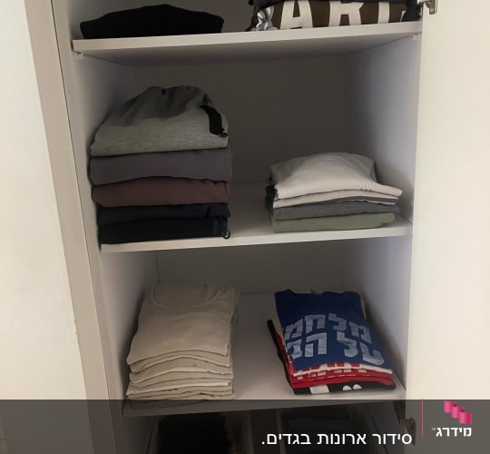בגדים מקופלים בארון עם סלסלות אחסון